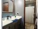 Bathroom with dark wood vanity, neutral tiling, and a shower behind a patterned curtain at 3080 Shue Rd, Salisbury, NC 28147