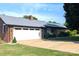 Traditional brick ranch home with a metal roof, attached garage, and long concrete driveway at 3080 Shue Rd, Salisbury, NC 28147