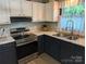 Modern kitchen featuring stainless steel appliances, stylish cabinetry, sink with faucet, and ample counter space at 3080 Shue Rd, Salisbury, NC 28147