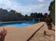 Inground pool in a backyard with gravel beds, plants, a privacy fence, and a glimpse of blue sky at 3080 Shue Rd, Salisbury, NC 28147