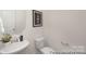 Clean half bathroom with a sleek white sink and fixtures, and a decorative art piece hanging above at 4044 Beacon Ave # 152, Monroe, NC 28110