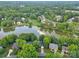 Aerial view capturing a peaceful lake surrounded by well-manicured lawns and beautiful homes in a leafy neighborhood at 5015 Foxbriar Trl, Charlotte, NC 28269