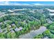 Scenic aerial view of neighborhood homes nestled among lush trees and a serene lake on a sunny day at 5015 Foxbriar Trl, Charlotte, NC 28269