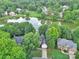 Birds-eye view highlighting residences near a tranquil lake, complemented by manicured lawns and mature trees at 5015 Foxbriar Trl, Charlotte, NC 28269
