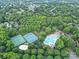 Overhead shot of community amenities featuring tennis courts and a pool amid lush greenery and well-planned neighborhood streets at 5015 Foxbriar Trl, Charlotte, NC 28269