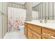 Bathroom featuring striped wall paper, floral shower curtain, and white countertops at 5015 Foxbriar Trl, Charlotte, NC 28269