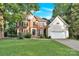 Well-maintained brick home with an attached two-car garage and lush green lawn at 5015 Foxbriar Trl, Charlotte, NC 28269