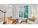 Bright foyer featuring hardwood floors, white trim, and a large window with plantation shutters at 5015 Foxbriar Trl, Charlotte, NC 28269