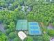 Aerial perspective of community tennis courts with green and blue surfaces surrounded by verdant trees in a planned neighborhood at 5015 Foxbriar Trl, Charlotte, NC 28269