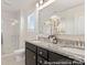 Bathroom featuring double sinks with granite countertops, modern fixtures, and a glass-enclosed shower, combining style and functionality at 6017 Santee River Way # 40, Belmont, NC 28012