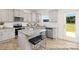 This kitchen offers a granite island with seating, stainless steel appliances, gray cabinetry and a view to the backyard at 6017 Santee River Way # 40, Belmont, NC 28012