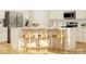 Bright kitchen features white cabinets, island with barstool seating and light wood floors at 6448 Fairfax Ct, Maiden, NC 28650