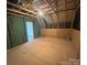 This unfinished attic space has a window, plywood flooring, and green sheathing at 707 Marion Dr, Matthews, NC 28105