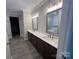 A spacious bathroom is designed with dual vanity sinks, wooden cabinets, and tile floors at 707 Marion Dr, Matthews, NC 28105