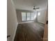 A bedroom offers hardwood floors, ceiling fan, neutral paint, and large windows for natural light at 707 Marion Dr, Matthews, NC 28105