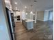 Spacious kitchen boasts stainless appliances, an island with sink, quartz counters, and access to the living area at 707 Marion Dr, Matthews, NC 28105