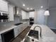 New kitchen features white cabinets, stainless steel appliances and large island with a sink and quartz countertop at 707 Marion Dr, Matthews, NC 28105