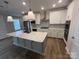 Kitchen featuring white cabinets, stainless steel appliances, a large island with a sink, and hardwood floors at 707 Marion Dr, Matthews, NC 28105