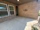 Covered outdoor patio with brick walls, ceiling fan, and concrete flooring at 707 Marion Dr, Matthews, NC 28105