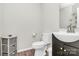Cozy half bathroom featuring tiled floors, storage cabinet, and decorative mirror above the sink at 902 Silverberry St, Gastonia, NC 28054