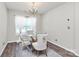 Bright dining room with a modern chandelier, glass-top table, and elegant chairs at 902 Silverberry St, Gastonia, NC 28054