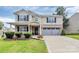 Charming two-story home featuring a well-manicured lawn, brick accents, and an attached two-car garage at 902 Silverberry St, Gastonia, NC 28054