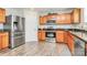 This eat-in kitchen features natural wood cabinets, stainless appliances, and a modern stainless refrigerator at 902 Silverberry St, Gastonia, NC 28054