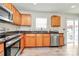This lovely kitchen features natural wood cabinets, stainless appliances, granite countertops, and light-filled views at 902 Silverberry St, Gastonia, NC 28054