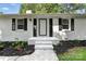 Home's entryway featuring a white door, black shutters, landscaping, and a freshly painted walkway at 104 Spargo St, Gastonia, NC 28056