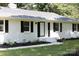 Home's entryway featuring a white door, black shutters, landscaping, and a freshly painted walkway at 104 Spargo St, Gastonia, NC 28056