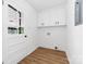 Clean laundry room with white cabinets, new flooring, and a bright exterior door at 104 Spargo St, Gastonia, NC 28056