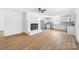 Open layout with fireplace and kitchen featuring white cabinets, stainless appliances, and new flooring at 104 Spargo St, Gastonia, NC 28056