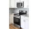 Close up of stainless steel oven and range with granite countertops and gray tile backsplash at 104 Spargo St, Gastonia, NC 28056