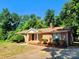 Well-maintained brick home featuring a cozy front porch and mature trees at 125 Circle Dr, Mount Holly, NC 28120