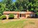 Charming brick ranch home with mature landscaping and inviting front porch on a sunny day at 125 Circle Dr, Mount Holly, NC 28120