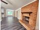 Open-concept living area showcasing a brick fireplace and hardwood floors at 125 Circle Dr, Mount Holly, NC 28120