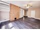 Large living room boasts a brick accent wall, built-in shelves, and a ceiling fan at 125 Circle Dr, Mount Holly, NC 28120
