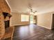 Cozy living area features a brick fireplace, ceiling fan, and hardwood floors at 125 Circle Dr, Mount Holly, NC 28120