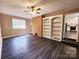Spacious living room featuring a ceiling fan, brick accent wall, and built-in shelves at 125 Circle Dr, Mount Holly, NC 28120