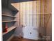 A functional utility room with built in shelving, fire extinguisher, and patterned wallpaper at 125 Circle Dr, Mount Holly, NC 28120
