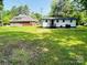Expansive backyard showcases a white home with a dark roof, surrounded by a lush green lawn at 20016 Walter Henderson Rd, Cornelius, NC 28031