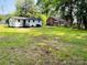An expansive backyard showcases a white home with a dark roof, surrounded by a lush green lawn at 20016 Walter Henderson Rd, Cornelius, NC 28031