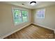 Bright bedroom featuring wood flooring, neutral walls, and two windows offering natural light at 20016 Walter Henderson Rd, Cornelius, NC 28031