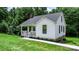 Charming white cottage-style home with covered porch and well-maintained front yard surrounded by lush greenery at 2704 Kool Park Ne Rd, Hickory, NC 28601