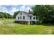 The back of a quaint two-story home featuring a sunroom and well-maintained landscaping at 2704 Kool Park Ne Rd, Hickory, NC 28601