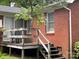 Cozy back porch with wooden railing and steps, perfect for relaxing outside on a red brick home at 506 Hearne Farm Rd, Mount Gilead, NC 27306