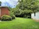 Expansive green backyard with a brick home on one side and a detached building on the other at 506 Hearne Farm Rd, Mount Gilead, NC 27306