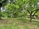 Large front yard with mature trees and landscaping surrounding the house, offering a serene setting at 506 Hearne Farm Rd, Mount Gilead, NC 27306