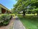 Brick home with lush landscaping, a sidewalk, and mature trees providing ample shade in the front yard at 506 Hearne Farm Rd, Mount Gilead, NC 27306