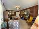 View of the living room with brick accent wall, patterned furniture, and vintage entertainment center at 506 Hearne Farm Rd, Mount Gilead, NC 27306